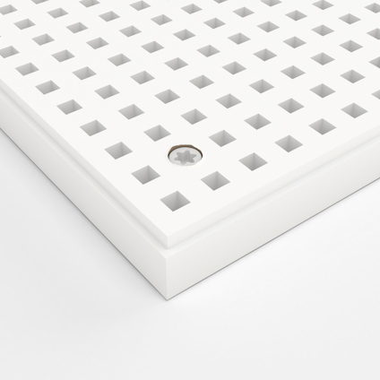 Vitt perforerat panel med rutnät och en synlig skruv i hörnet.