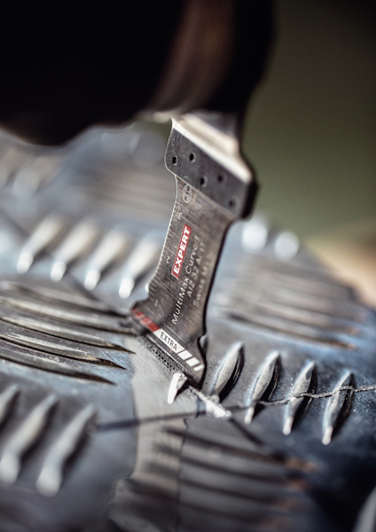 Närbild på ett skridskoskydd som slipas med en handhållen verktygsslipmaskin.