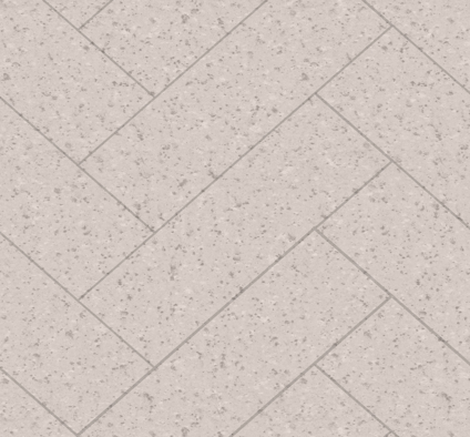 Ljus terrazzo liknande yta med fiskbensmönster och små mörka prickar.