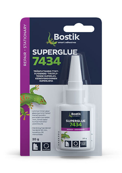 Blisterförpackning med Bostik Superglue 7434, innehåller en vit flaska med pipkork och färgglad etikett med text på flera språk.