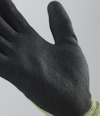 Svart, texturerad handske med stickat, gult skaft, sedd från sidan mot en grå bakgrund.