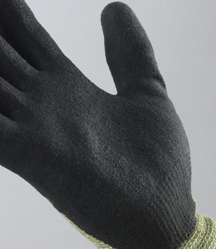 Svart, texturerad handske med stickat, gult skaft, sedd från sidan mot en grå bakgrund.