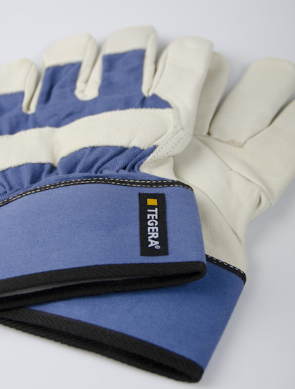 Blå och vita arbetshandskar med ett svart och gult märke som säger "Tegera".