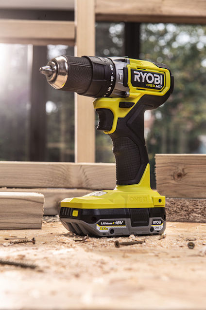 Batteridriven borrmaskin i grönt och svart, märkt "RYOBI ONE+". Trästruktur i bakgrunden.