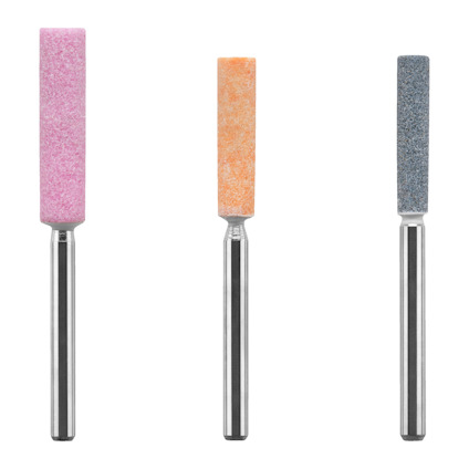 Tre cylindriska slipstift i rosa, orange och grå färg med metallhandtag på vit bakgrund.
