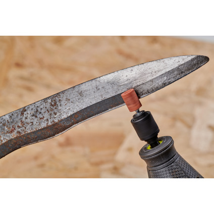 En slipmaskin används för att slipa en rostig kniv, med grovt slippapper monterat på verktyget.