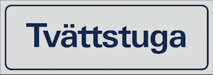 Rektangulär skylt med texten "Tvättstuga" i blå bokstäver på ljus bakgrund.