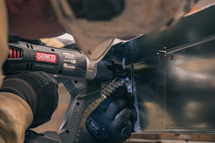 Person använder en Senco skruvdragare för att säkra metallmaterial.
