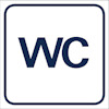 Vitt kvadratisk skylt med blå texten "WC" i mitten, omgiven av blå ram.