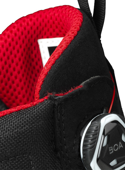 Svart snörkänga med rött foder och vit BOA-dial för snörning.