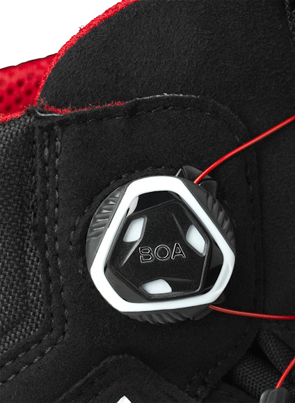 Skosnörningssystem med svart BOA-vred och röd snörning på svart bakgrund.