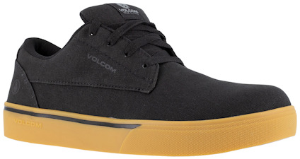 Svart sko med lågt skaft och guldfärgad sula. Snörad med svarta skosnören. Texten "VOLCOM" syns på sidan.