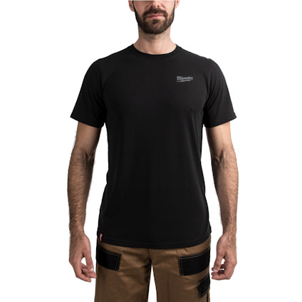 Man i svart t-shirt och bruna byxor mot vit bakgrund.