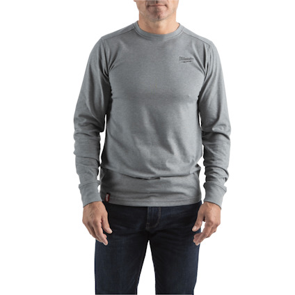 Man i grå långärmad tröja och mörka jeans, står mot en vit bakgrund.
