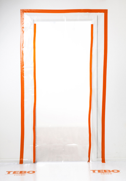 Transparent plastdörr med orange tejp längs kanterna och texten "TEBO" på golvet nedanför.