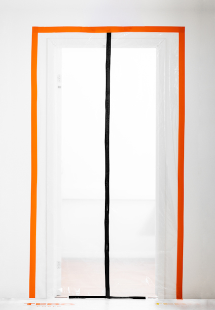 Plastdörr med magnetisk öppning, omgiven av orange tejp.