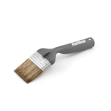 Pensel med grått plastgrepp och borst av beige färg. Märkt med "Byggtillbehör" på handtaget.