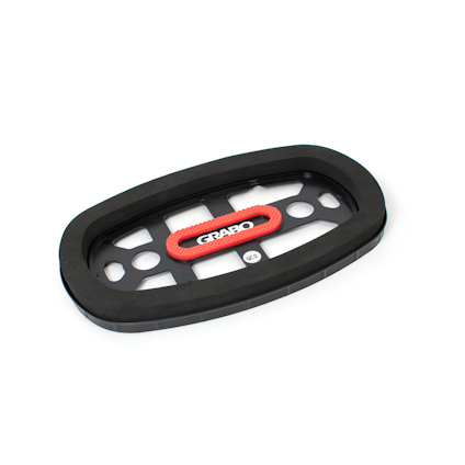 Svart oval gummipackning med röd märkning "GRABO" på en platt metalldel med hål.