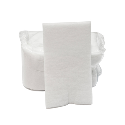 Vit grovfilterduk stående framför en rulle inplastad filtmaterial.