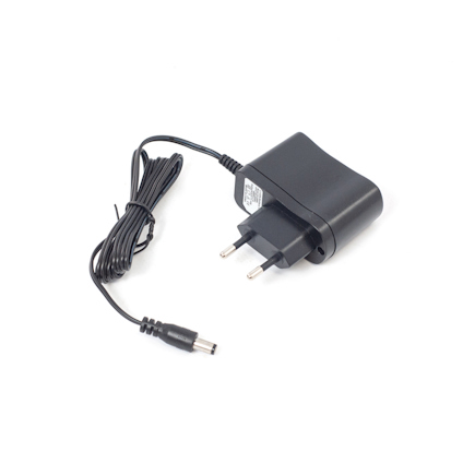 Svart laddare med tvåstiftskontakt och ihopbunden kabel på vit bakgrund.