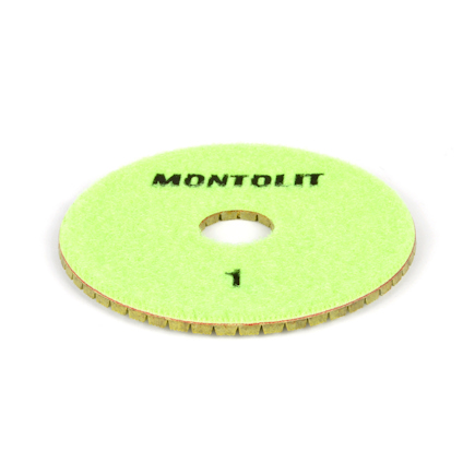 Rund, grön polerpad med perforerat mittdel och texten "MONTOLIT 1" i svart på ovansidan.