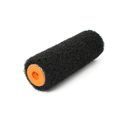 Svart spackelroller med orange centrum, ligger på en vit bakgrund.