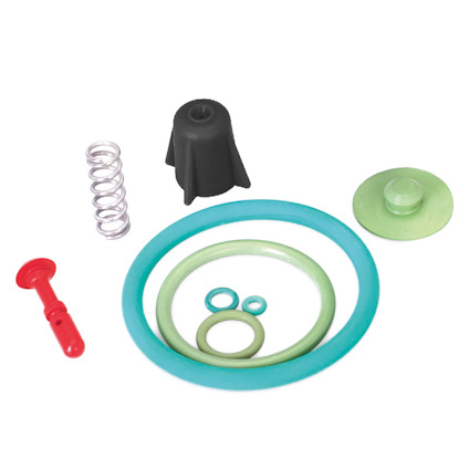 Olika färgade och formade packningar, fjäder och plastdetaljer på vit bakgrund.