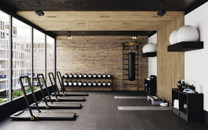 Modernt gym med löpband, träpaneler, speglar och träningsredskap som medicinbollar och hantlar.