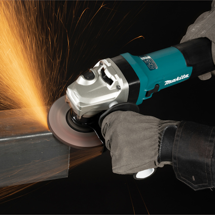 En person använder en Makita-vinkelslip för att skära metall, gnistor flyger från skärytan.