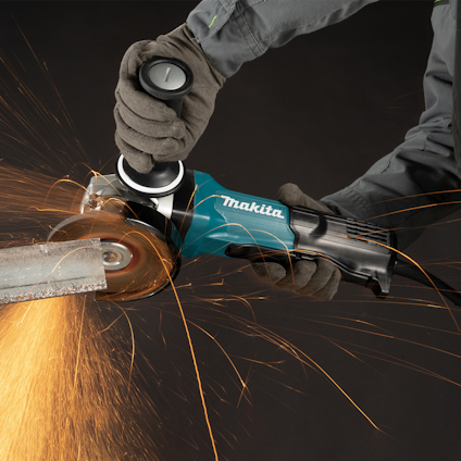 En person slipar metall med en blå Makita vinkelslip, gnistor flyger.