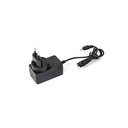 Svart nätadapter med EU-kontakt och tillhörande svart kabel, liggande på en vit yta.
