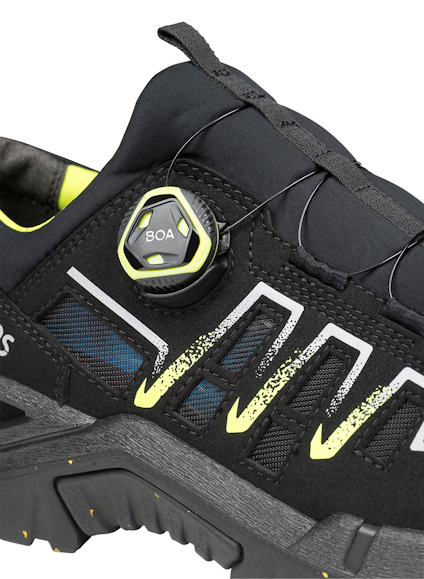 Svart sko med BOA-snörningssystem och gula detaljer.