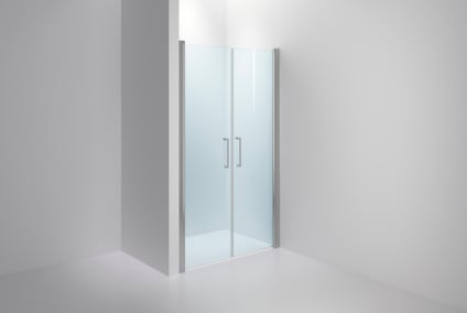 Duschvägg i glas med två dörrar och metallhandtag, monterad i vit minimalistisk badrumsmiljö.