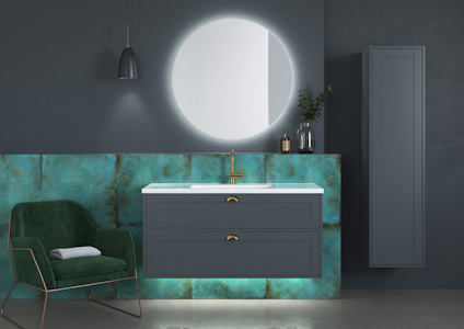 Modern bathroom with green chair, illuminated round mirror, teal wall with floating sink unit, and tall cabinet.