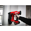 En röd Milwaukee FUEL spikpistol som håller på att användas mot en dörrkarm.