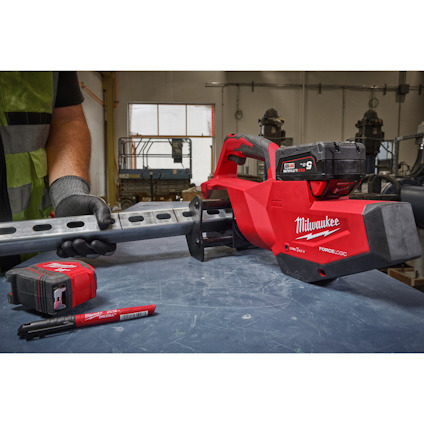 Batteridriven såg från Milwaukee på ett bord bredvid en batteriladdare och markörpenna.
