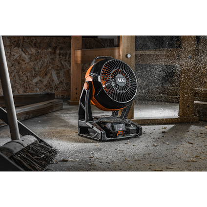 Fläkt från AEG i ett dammigt rum med träytor och en kvast i förgrunden.