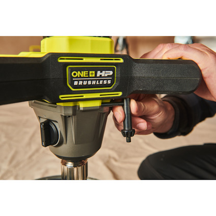 Närbild på en hand som håller i en grön och svart omrörare av märket RYOBI med texten "ONE+ HP BRUSHLESS".