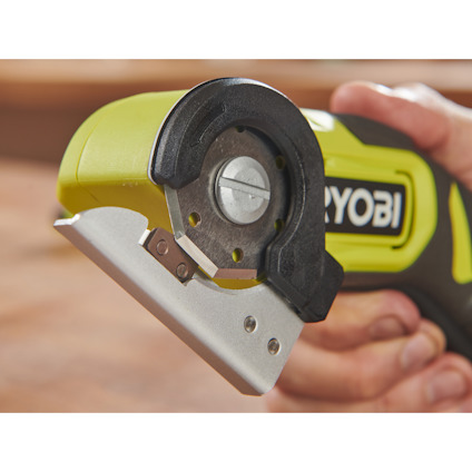 En batteridriven multisax av märket Ryobi hålls i en hand, fokuserar på bladet.
