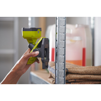 En person använder magneterna för att fästa lampan med klämfäste av märket Ryobi på en yta av metall.