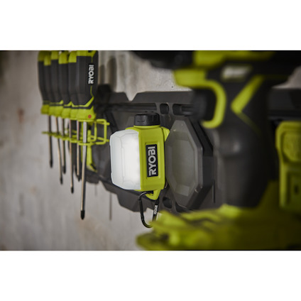 Områdeslampa av märket RYOBI som sitter på en LINK vägg, flera skruvmejslar i hållare.