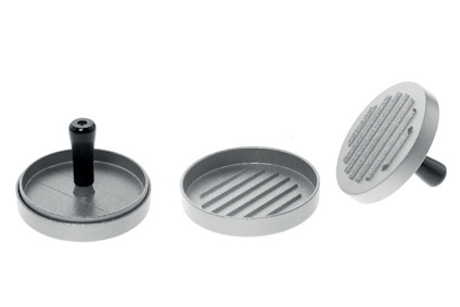 Tre delar av en hamburgerpress i metall med svart handtag, locket och bottenplattan har räfflad yta.