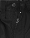 Svart tyg med synliga sömmar, blixtlås och en metallknapp med texten "Carhartt".