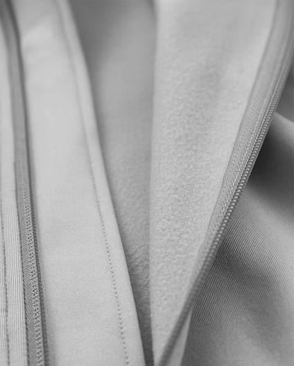 Närbild av grå textil med synliga sömmar och veck.