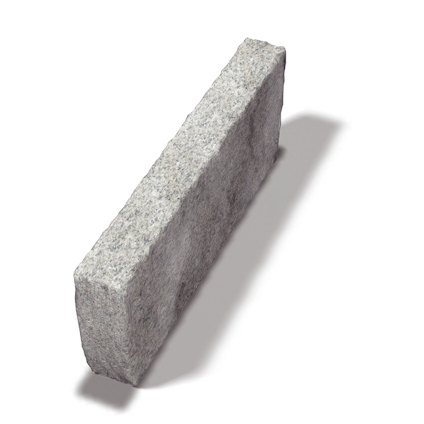 Rektangulär grå stenblock med något ojämn yta. Skugga faller diagonalt från stenen.