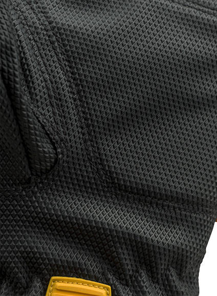 Svart texturerat material med mönster av små rutor. Gul detalj syns längst ner i bilden.