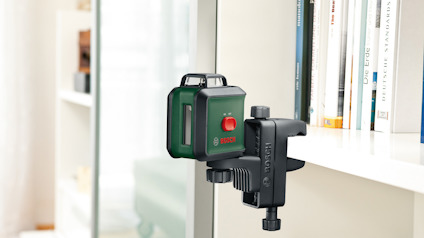 Grön Bosch laserpass med klämfäste monterad på en hyllkant.