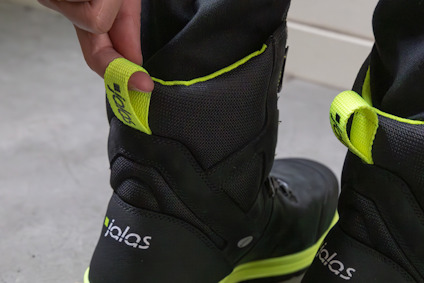 Svart sko med neongröna detaljer och texten "jalas" på häl och dragflärp.