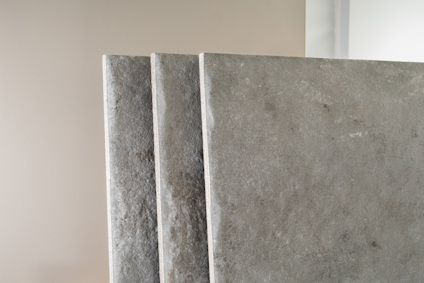 Tre betongplattor stående på rad mot en ljus bakgrund.