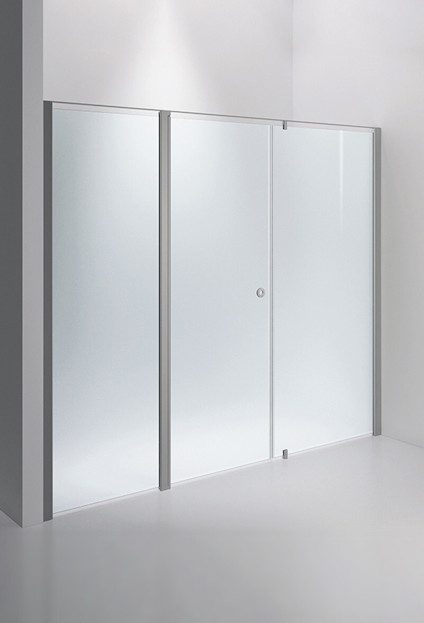 Frostat duschvägg med metallram och dörr handtag i en ljus badrumsmiljö.